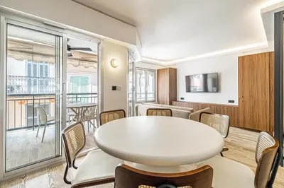 a room with a table and chairs and a balcony at Charming flat - 2BR-6P - Cannes in Cannes