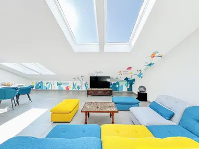 a living room with blue and yellow furniture and a table at Sky Croisette - Palais des Festivals et des Congrès in Cannes