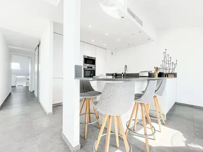 a kitchen with white walls and a counter with stools at Sky Croisette - Palais des Festivals et des Congrès in Cannes
