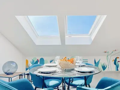a dining room with a table and blue chairs at Sky Croisette - Palais des Festivals et des Congrès in Cannes