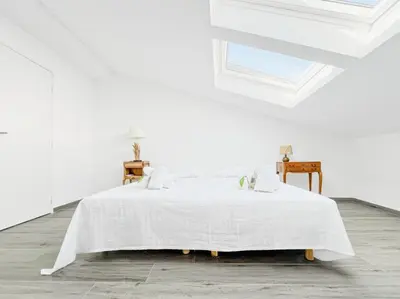 a white bedroom with a large white bed with a window at Sky Croisette - Palais des Festivals et des Congrès in Cannes