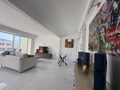 a living room with a couch and a table at Cannes 2 suites 2 terrasses in Cannes