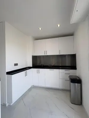 a kitchen with white cabinets and a black microwave at Cannes 2 suites 2 terrasses in Cannes