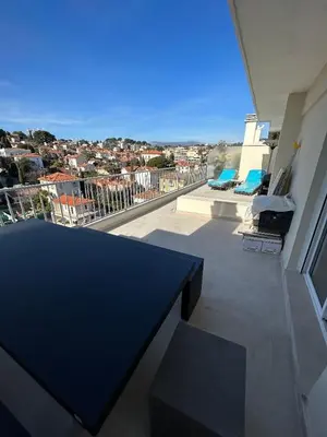 a black table on a balcony with a view of a city at Cannes 2 suites 2 terrasses in Cannes