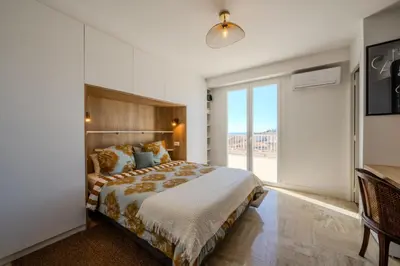 a bedroom with a large bed and a large window at Appartement avec Terrasse et Vue Mer in Cannes