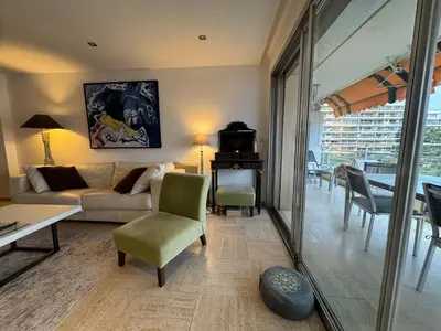 a living room with a couch and a table at 90 m2 Palm Beach apartment with 2 balconies Very stylish and central in Cannes