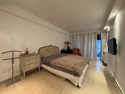 a bedroom with a bed and a dresser and a television at 90 m2 Palm Beach apartment with 2 balconies Very stylish and central in Cannes
