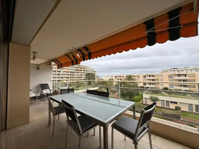 a table and chairs on a balcony with a view at 90 m2 Palm Beach apartment with 2 balconies Very stylish and central in Cannes