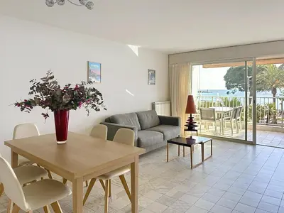 a living room with a table and a couch at Cozy 2-bedroom apartment with terrace, sea view and parking in Cannes in Cannes