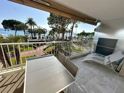 a balcony with a table and chairs and a view of the ocean at Cozy 2-bedroom apartment with terrace, sea view and parking in Cannes in Cannes