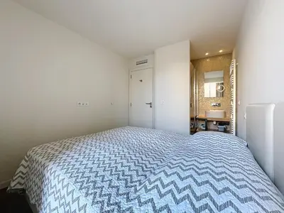 a small bedroom with a bed and a bathroom at Cozy 2-bedroom apartment with terrace, sea view and parking in Cannes in Cannes