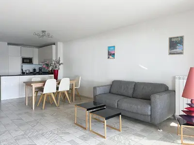 a living room with a couch and a table at Cozy 2-bedroom apartment with terrace, sea view and parking in Cannes in Cannes
