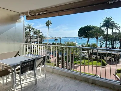 a balcony with a table and a view of the ocean at Cozy 2-bedroom apartment with terrace, sea view and parking in Cannes in Cannes