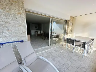 a patio with a table and chairs and a dining room at Cozy 2-bedroom apartment with terrace, sea view and parking in Cannes in Cannes
