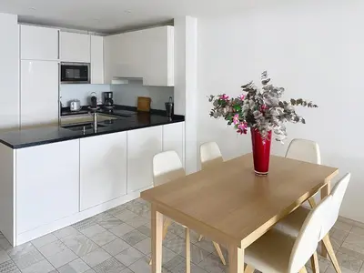 a kitchen with a wooden table with a vase of flowers on it at Cozy 2-bedroom apartment with terrace, sea view and parking in Cannes in Cannes