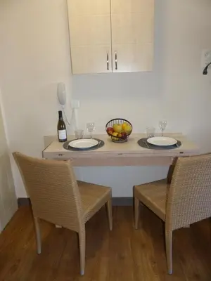 a dining room table with two plates and two chairs at Appartement 4 personnes ,résidence vue mer et jardin, piscine, parking in Cannes