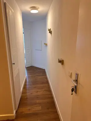 a hallway with white walls and a wooden floor at Appartement 4 personnes ,résidence vue mer et jardin, piscine, parking in Cannes