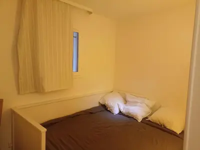 a room with a bed with two pillows and a window at Appartement 4 personnes ,résidence vue mer et jardin, piscine, parking in Cannes