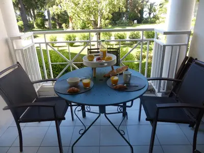 a blue table with food on it on a balcony at Appartement 4 personnes ,résidence vue mer et jardin, piscine, parking in Cannes