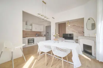 a white kitchen with a white table and chairs at Sublime appartement luxe T3 incroyable Jardin Plein cœur Cannes in Cannes