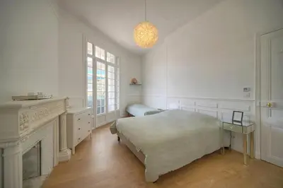 a white bedroom with a bed and a fireplace at Sublime appartement luxe T3 incroyable Jardin Plein cœur Cannes in Cannes