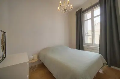 a bedroom with a bed and a window with a chandelier at Sublime appartement luxe T3 incroyable Jardin Plein cœur Cannes in Cannes