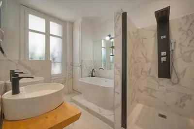 a white bathroom with a tub and a sink and a bath tub at Sublime appartement luxe T3 incroyable Jardin Plein cœur Cannes in Cannes