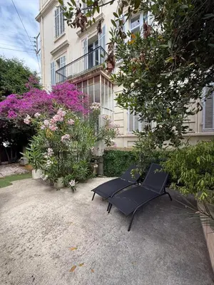 a black bench sitting in front of a building at Sublime appartement luxe T3 incroyable Jardin Plein cœur Cannes in Cannes