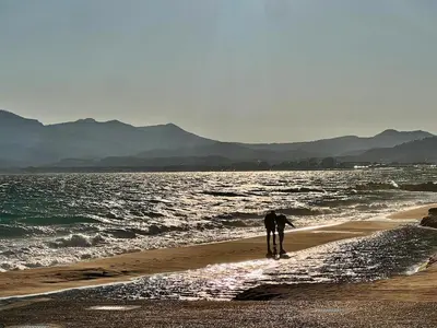 two people standing on a beach near the water at Luxury Appartment with terrace and side sea view in Cannes