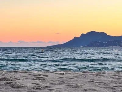 a beach with a view of the ocean at sunset at Luxury Appartment with terrace and side sea view in Cannes