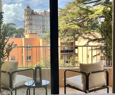 a balcony with two chairs and a view of a building at Luxury Appartment with terrace and side sea view in Cannes