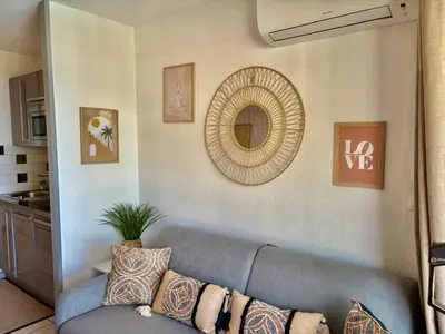 a living room with a blue couch and a mirror at Palme d'Azur 409 in Cannes