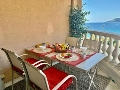 a table with breakfast food on a balcony with the ocean at Palme d'Azur 409 in Cannes