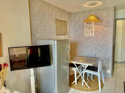 a kitchen with a refrigerator and a table with chairs at Palme d'Azur 409 in Cannes