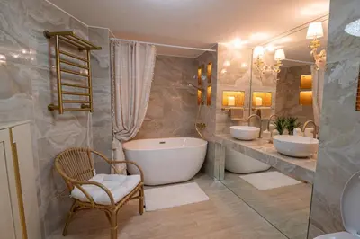 a bathroom with two sinks and a tub and a chair at 2-bedroom luxurious apartment with balcony and parking in Cannes