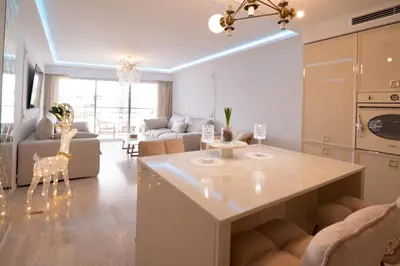 a kitchen and living room with a table and chairs at 2-bedroom luxurious apartment with balcony and parking in Cannes