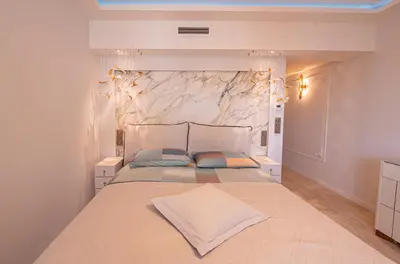 a bedroom with a large bed with a stone wall at 2-bedroom luxurious apartment with balcony and parking in Cannes