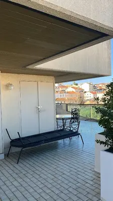 a black bench sitting on a patio with a table at villa sur le toit au centre de Cannes in Cannes