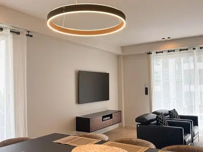 a living room with a television and a table and chairs at GRAY DUBOY D'ANGERS Luxury 3 bedrooms Croisette in Cannes