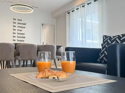 a table with a plate of food and two glasses of orange juice at GRAY DUBOY D'ANGERS Luxury 3 bedrooms Croisette in Cannes