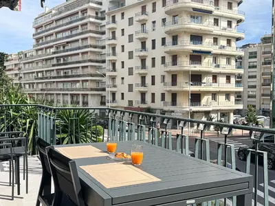 a table on a balcony with two glasses of orange juice at GRAY DUBOY D'ANGERS Luxury 3 bedrooms Croisette in Cannes