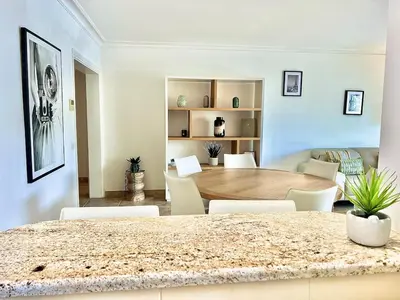 a living room with a wooden table and chairs at Luxurious 2-bedroom Pointe Croisette, Sea view, private parking in Cannes