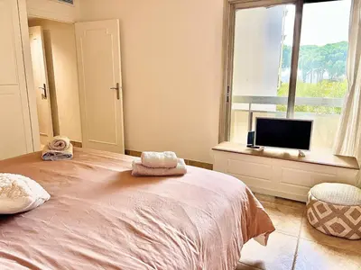 a bedroom with a large bed and a window at Luxurious 2-bedroom Pointe Croisette, Sea view, private parking in Cannes