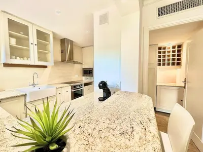 a kitchen with a counter and a sink and a table at Luxurious 2-bedroom Pointe Croisette, Sea view, private parking in Cannes