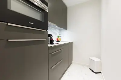 a kitchen with black cabinets and white floors at Gray d'Albion 3i7 YourHostHelper in Cannes