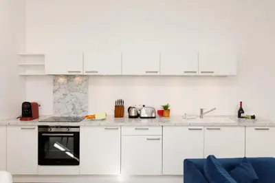 a white kitchen with white cabinets and appliances at Modern 3 bedroom apartment ideally located in Cannes