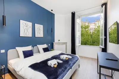 a bedroom with a large bed and a blue wall at Modern 3 bedroom apartment ideally located in Cannes