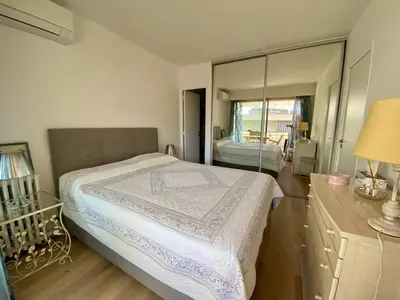 a bedroom with a bed and a dresser with a mirror at Cannes - Latour-Maubourg - 2 P rénové tout confort in Cannes