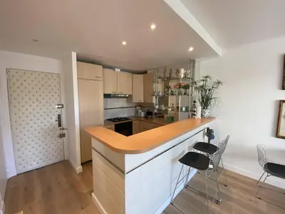a kitchen with a counter and chairs in a room at Cannes - Latour-Maubourg - 2 P rénové tout confort in Cannes