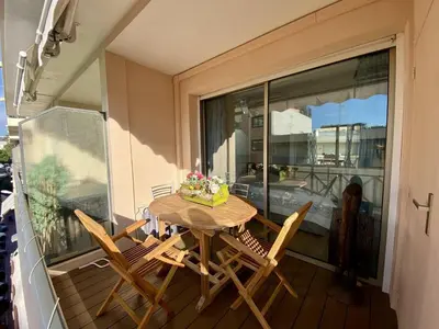 a table and chairs on a balcony with a window at Cannes - Latour-Maubourg - 2 P rénové tout confort in Cannes
